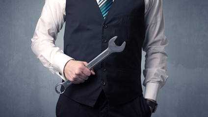 Businesman standing with tool on his hand