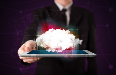 Businessman holding tablet with cloud graphic
