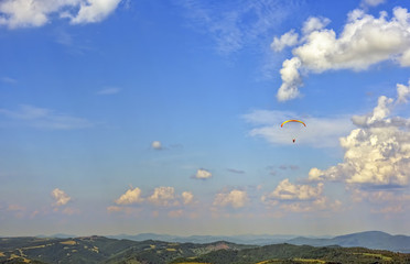 Skydiver flies to the skyline through the clouds