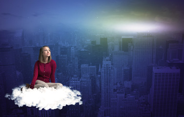 Woman sitting on cloud above the city