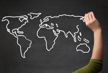 Adult drawing world map on chalkboard