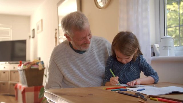 Grandfather And Granddaughter Colouring Picture Together