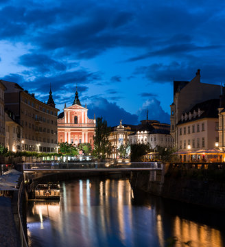 Center of Ljubljana at night Ljubljanica river still water reflecting street lights old european architect 
