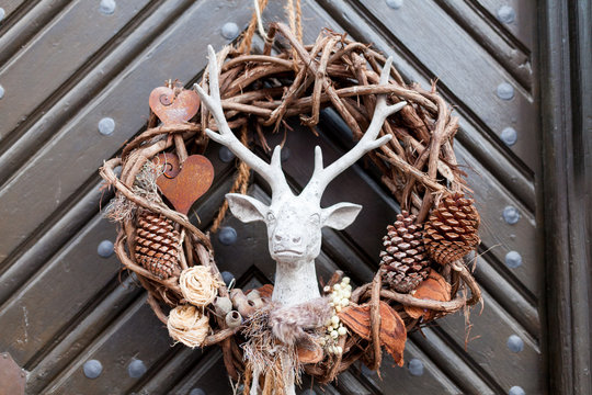 Decorative christmas season wrath with a deer on a brown door