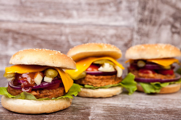 Delicious burgers on wooden background. Fast and tasty food