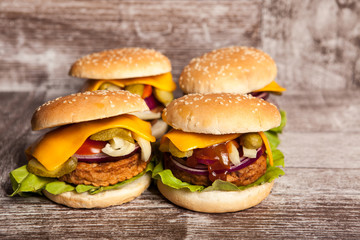 Delicious tasty hamburgers on wooden background. Fast and tasty food