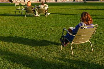 People are resting on the lawn in the autumn park