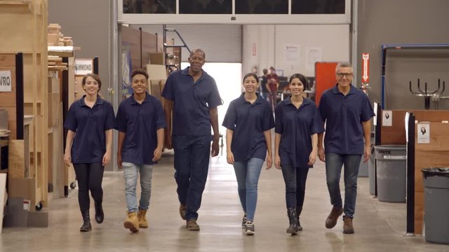 Engineers And Apprentices Walk Towards Camera In Factory
