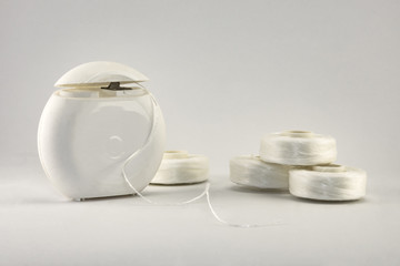 dental floss thread for cleaning teeth close-up on a white background together with mint gum pads