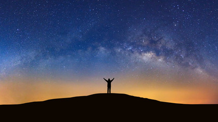 Panorama landscape with milky way, Night sky with stars and silhouette of a standing sporty man with raised up arms on high mountain. - Powered by Adobe