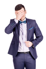 portrait young businessman covering his eyes with his hand. emotions, facial expressions, feelings, body language, signs. image on a white studio background.