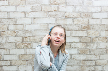 teen girl talking on the phone on the wall background