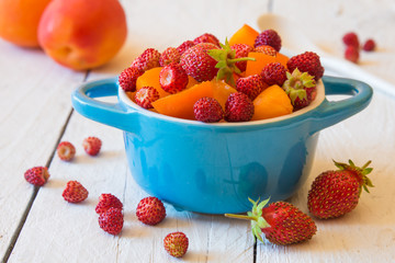Fruit salad with wild strawberries in a bowl