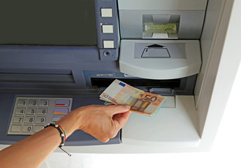 hand of young woman while withdrawing banknotes 50 euros from an