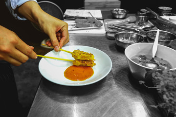 art food, fusion food, The chef's hands are arranging dishes, Pork Satay with Peanut Sauce 