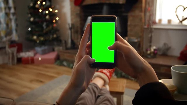 Woman On Line With Mobile Phone In Room Ready For Christmas