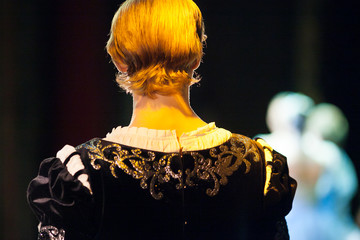 performance, illumination, theater concept. back of the head of man in gorgeous costume of prince,...