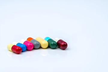Colorful of antibiotic capsules pills in a row on white background with copy space. Drug resistance, antibiotic drug use with reasonable, health policy and health insurance concept.