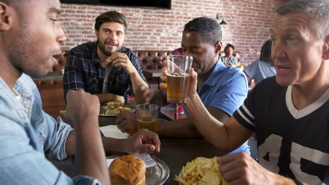 Group Of Male Friends Eating Out In Sports Bar Shot On R3D
