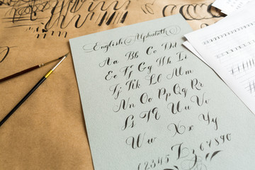 lettering, technique, drawing concept. english alphabeth written in italic style with elegant and smooth lines maded with help of thin tip of the brush and black ink