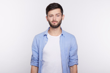 Unhappy and sad Caucasian student grimacing, displeased with his failure on exams. Young dissatisfied employe disappointed with results of examination interview. Human face expressions and emotions.