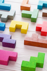Different colorful shapes wooden blocks on wooden background.