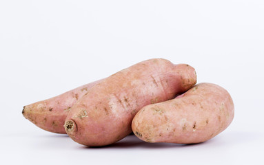 Raw sweet potato on a white background.
