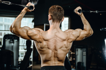 Handsome model young man training back in gym