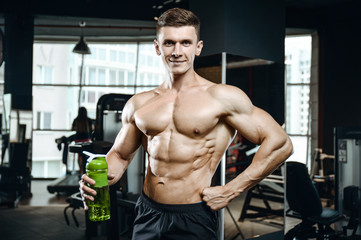 Fototapeta na wymiar Handsome model young man takes sports nutrition