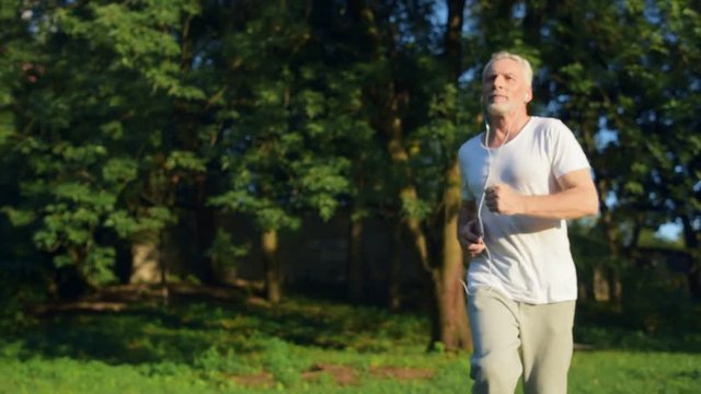 Confident senior man jogging in the park