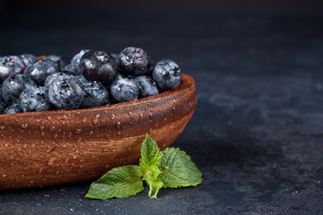 Fresh blueberries with a leaf of mint in the heart-shaped bowl