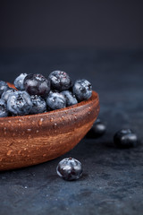 Fresh blueberries with a leaf of mint in the heart-shaped bowl