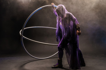 Assassin. Fairy-tale character in a bright purple suit with a hood and an extraordinary weapon.