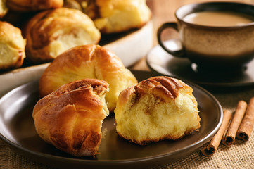 Homemade bread buns with cinnamon and cup of tea.