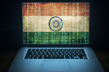 Indian hacker and computer expert. Laptop with binary computer code and India flag on the screen. Internet and network security.