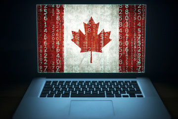 Canadian hacker. Laptop with binary computer code and Canada flag on the screen. Internet and...