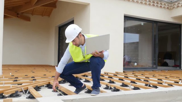 handsome young man foreman architect supervising a new house construction site
