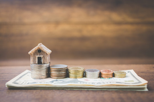 Money and house model on wooden background , Finance and banking concept.