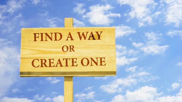 Find a way or create one. Words on a wooden sign against time lapse clouds in the blue sky. 