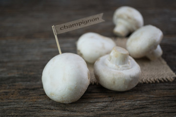 Fresh organic champignon mushrooms on wood background