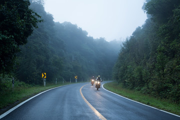 Motorcycle on foggy road in mystery land