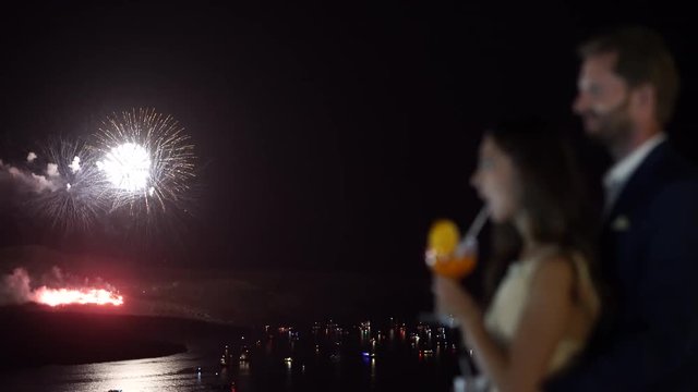 4k travel video couple watching fireworks over island and sea with many boats
