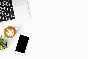 White office desk table with smartphone, laptop computer and cup of coffee. Top view with copy space, flat lay.