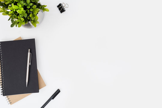 White office desk table with notebooks and pens. Top view with copy space, flat lay.