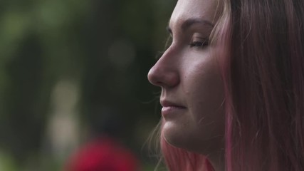 Slow motion handheld teen girl stand on sidewalk in town and wind blows her hair side shot