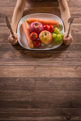 Kind vor Teller mit Obst und Gemüse