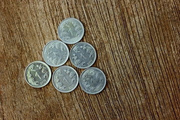 Indian coin on wooden texture