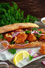 Chicken sandwich with mustard sauce and red onion crumpled paper