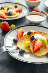 Homemade Pancakes with Blueberry, Strawberry, green Grape and honey syrup. served on plate