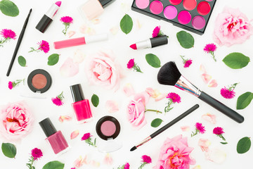 Feminine desk with woman cosmetics and pink roses on white background. Flat lay, top view. Beauty background for woman